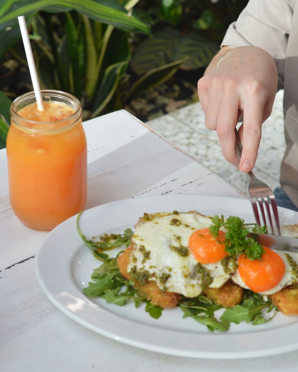 Fresh juice and eggs on a hash brown stack at Nadia's Café